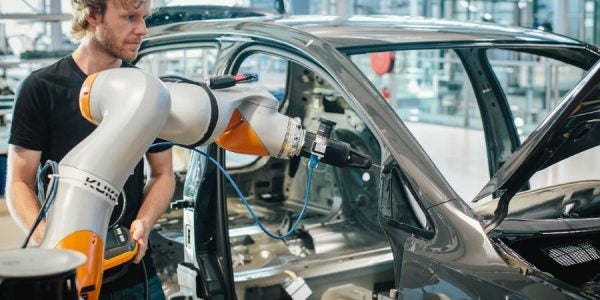 Un robot aplica la imprimación para el pegado de las ventanas laterales, luego el sistema de la cámara verifica la calidad.