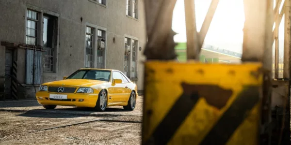 Vista tres cuartos delantera izquierda de un Mercedes-Benz SL500 amarillo